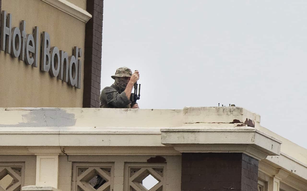 A sniper in military uniform on top of a building 