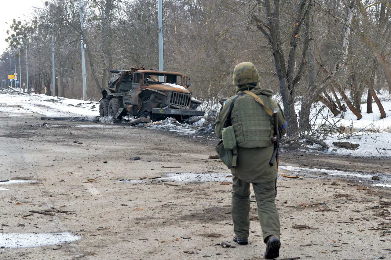 A destroyed Russian army multiple rocket launcher is seen on the side of a road.