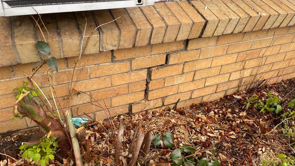 A significant crack in the brick exterior of a house