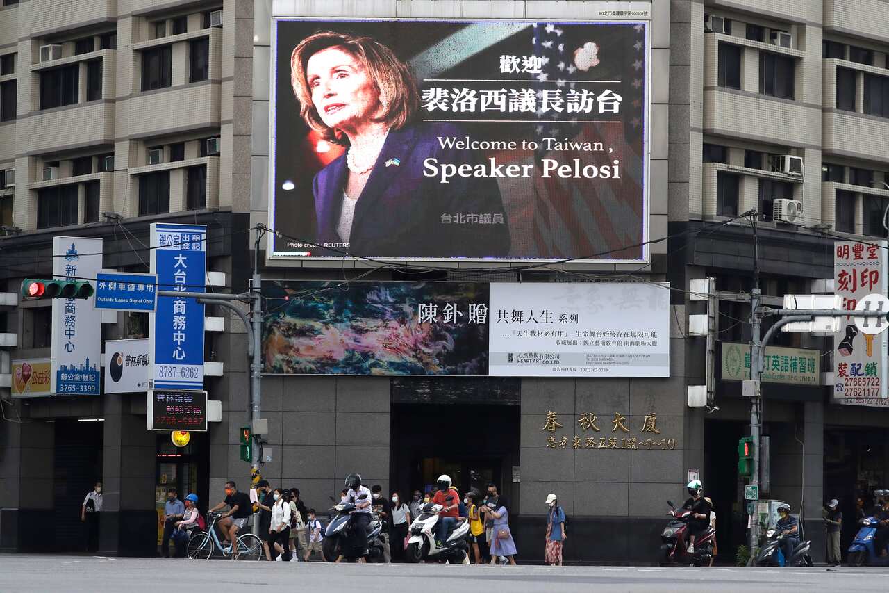 People walk past a billboard welcoming U.S. House Speaker Nancy Pelosi, in Taipei, Taiwan, August 3, 2022