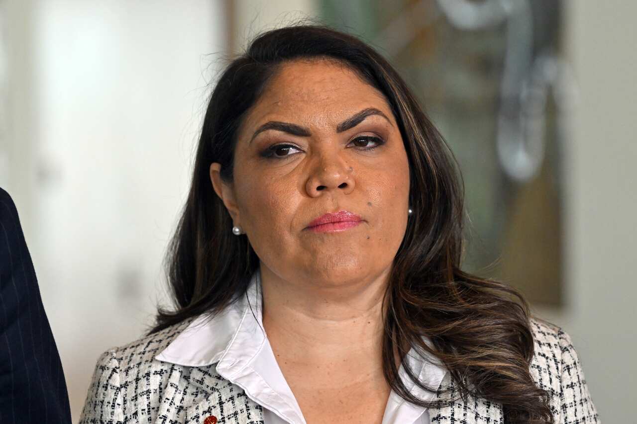 A woman wearing a black and white top standing in a hallway.