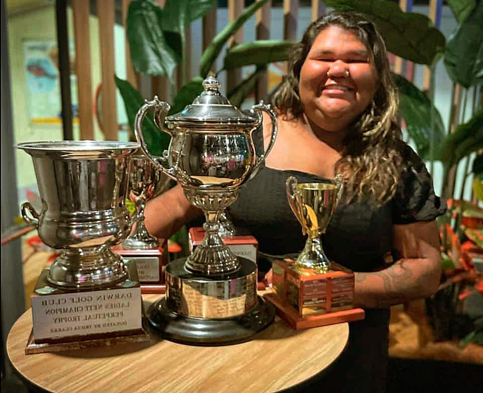 Syke Lampton stands with some of her golf trophies at the Darwin Golf Club