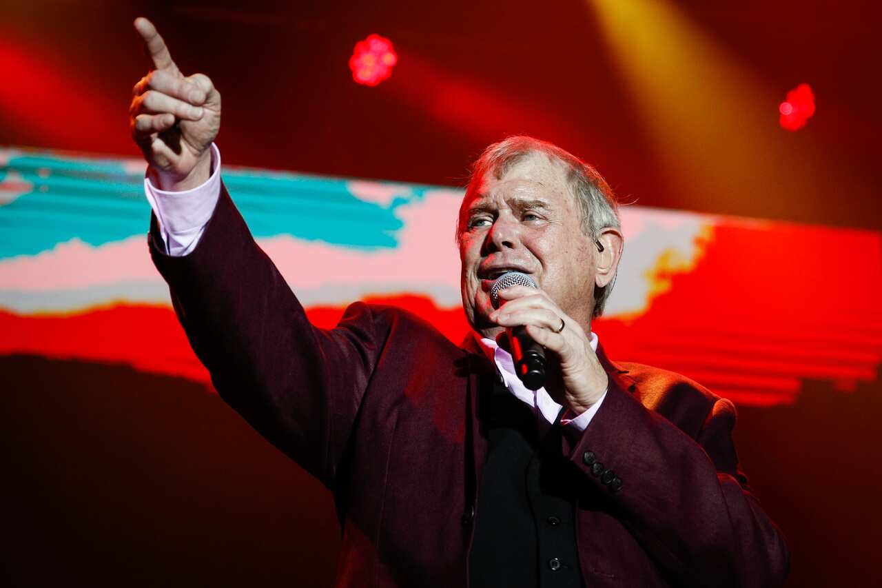 John Farnham singing on stage.