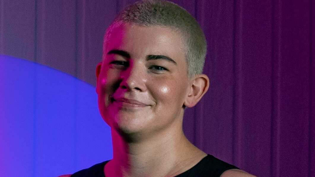 Woman with short blonde hair looking at camera.