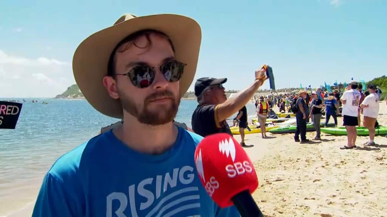 A man speaking to a journalist.