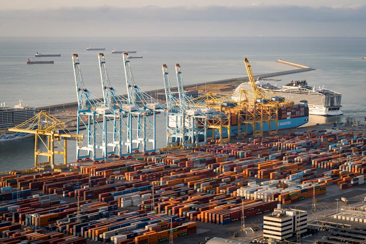 Rows of shipping containers line the port as cargo ships rest at the docks.