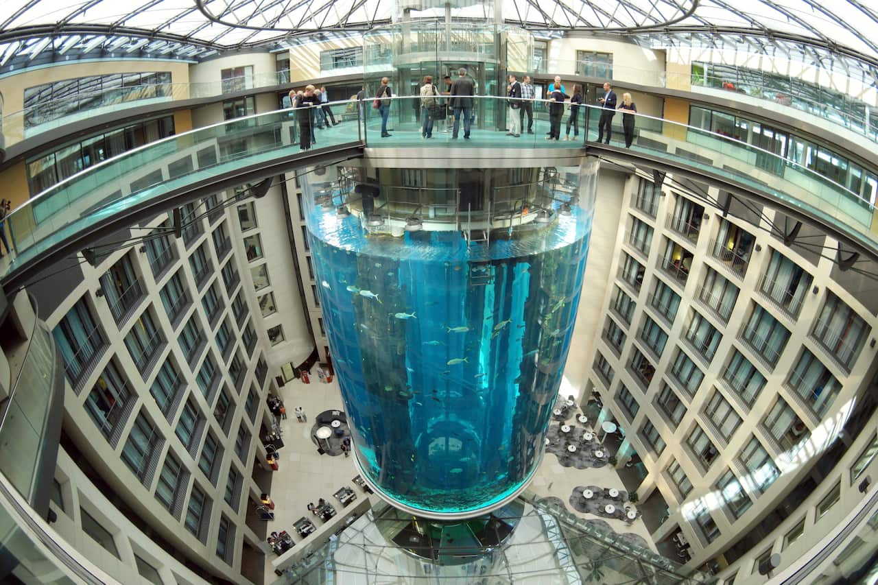 A massive cylindrical aquarium in a hotel lobby