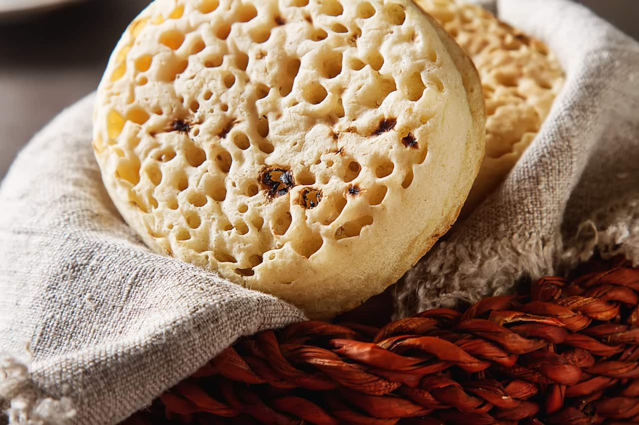 Hot Home made toasted crumpets served with honey and jams. Dark wood background. British breakfast.