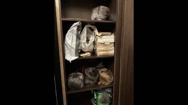 Wigs and bags in a cupboard.