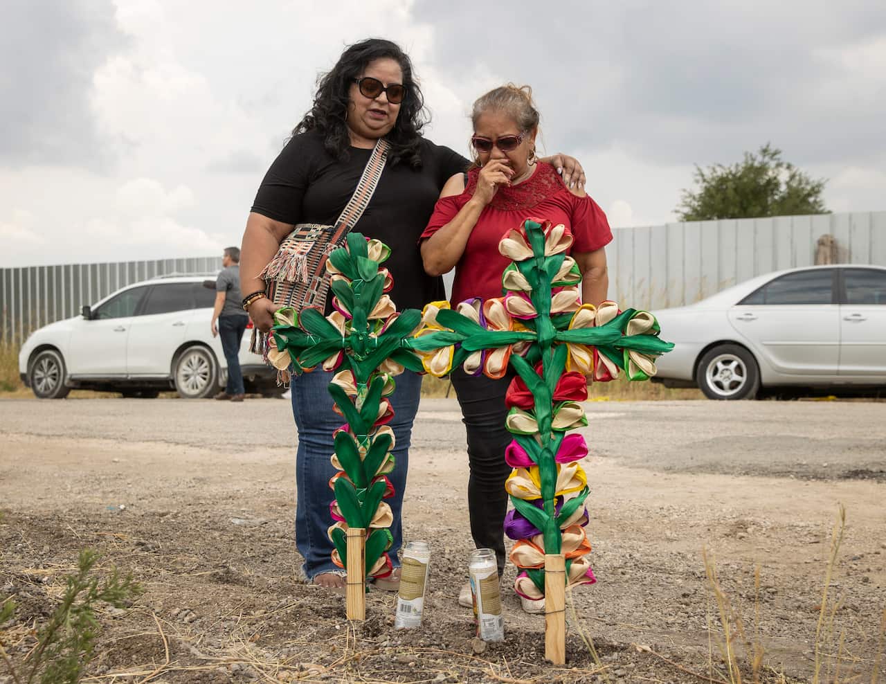 Two women at a makeshift memorial.