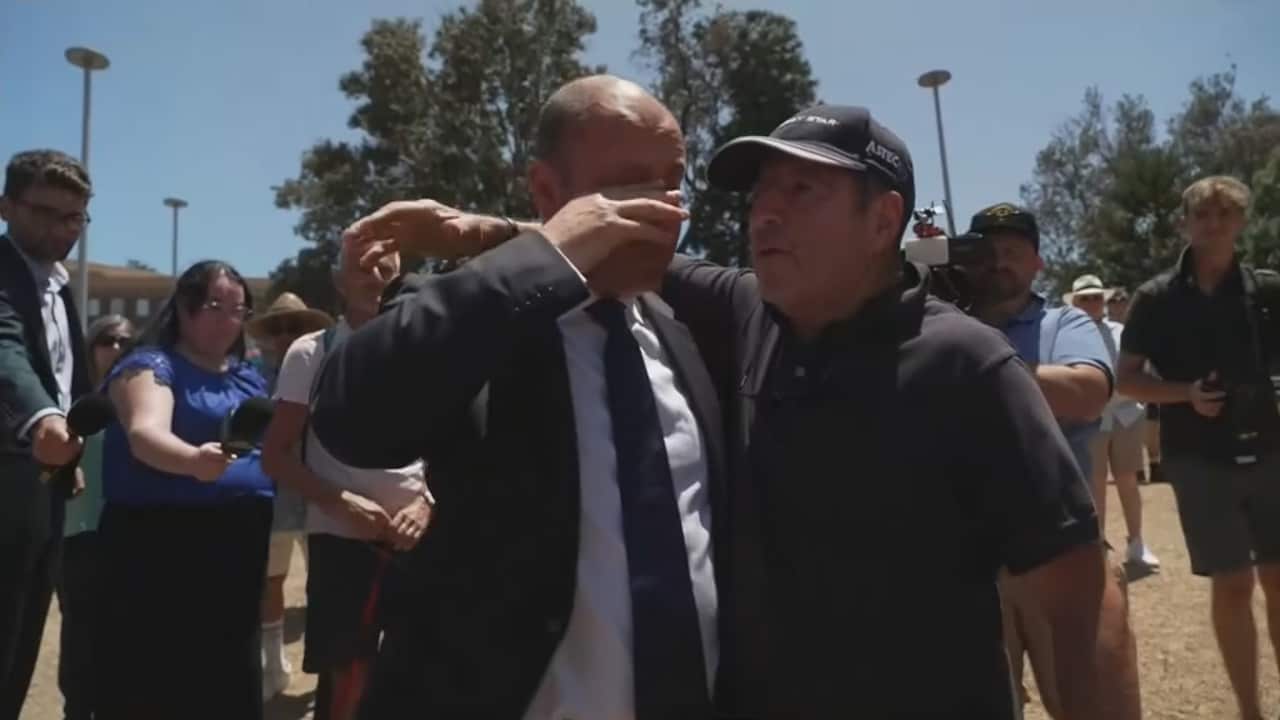 Former Liberal MP Josh Frydenberg wipes his face