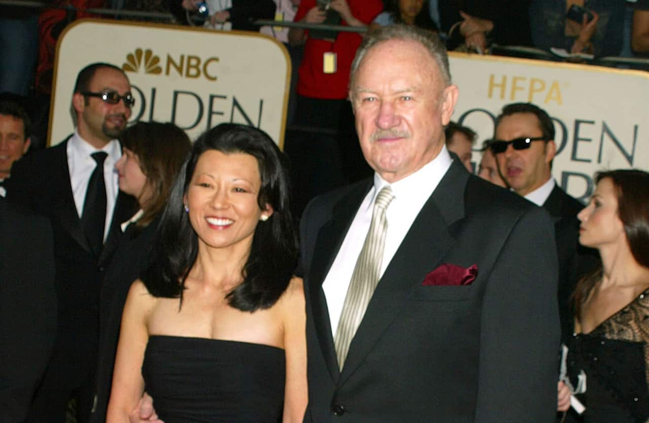 A woman and man standing in front of a sign that reads "Golden Globe Awards".