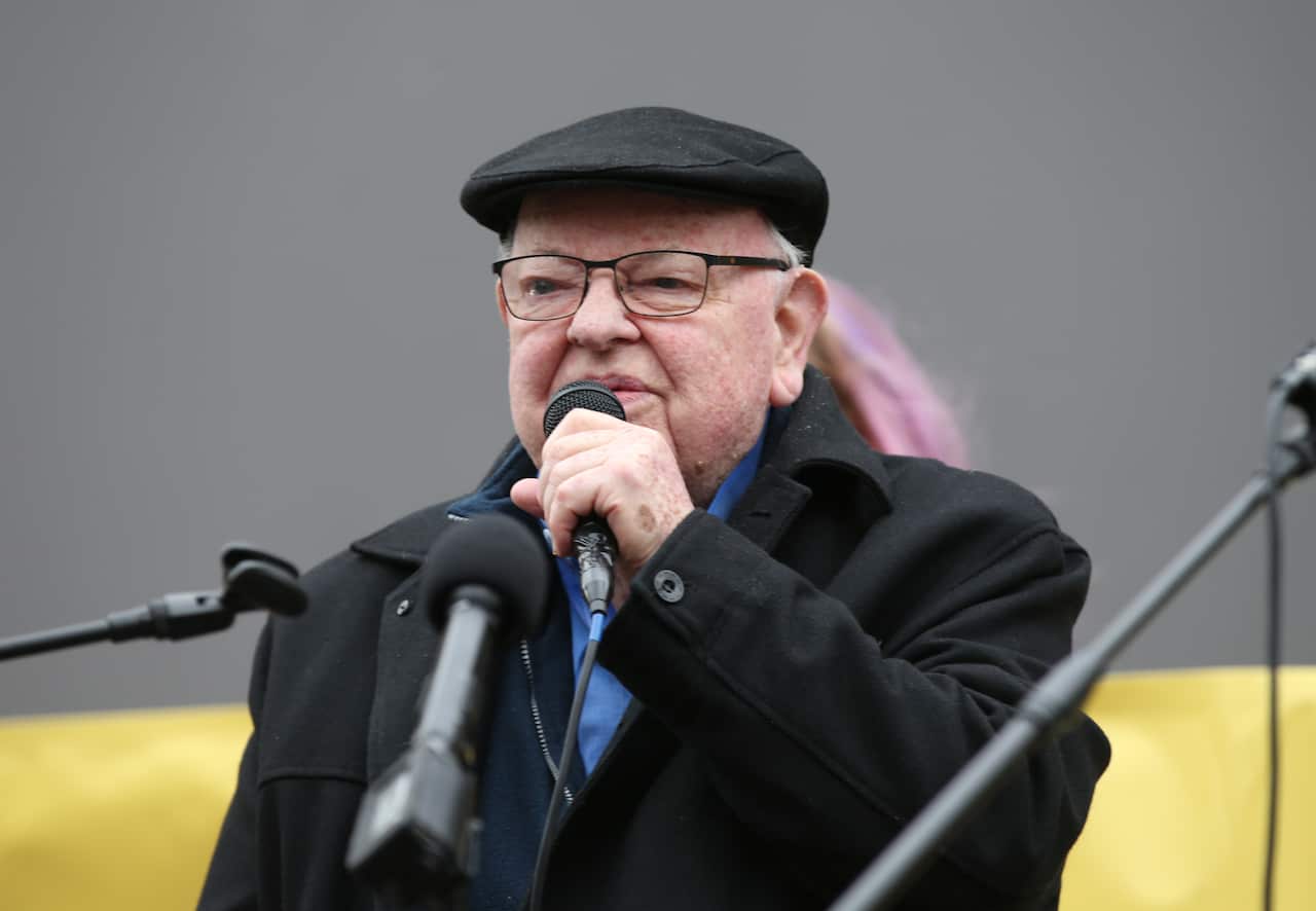 Father Bob Maguire speaking into a microphone
