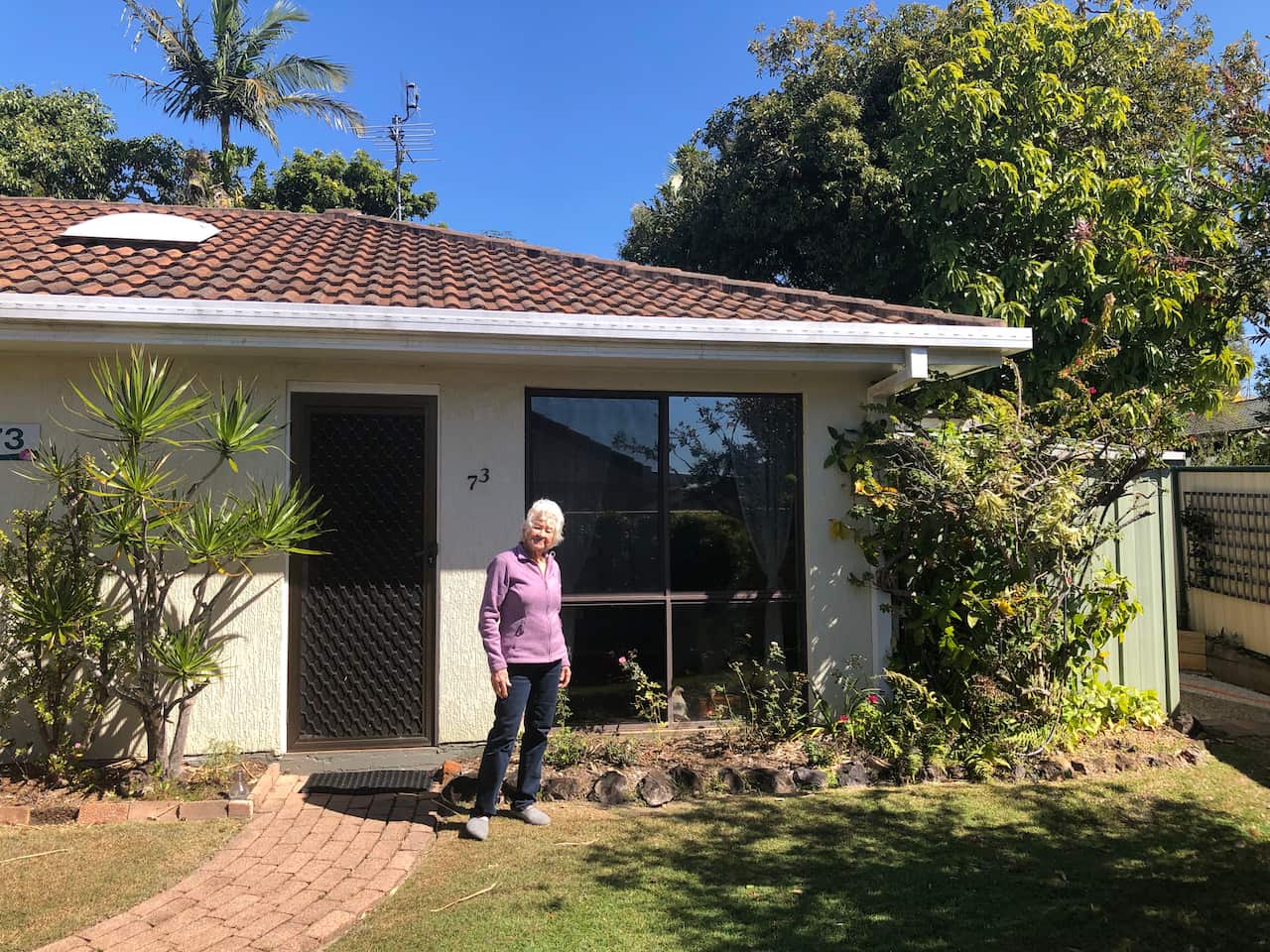 A woman standing in front of a house.