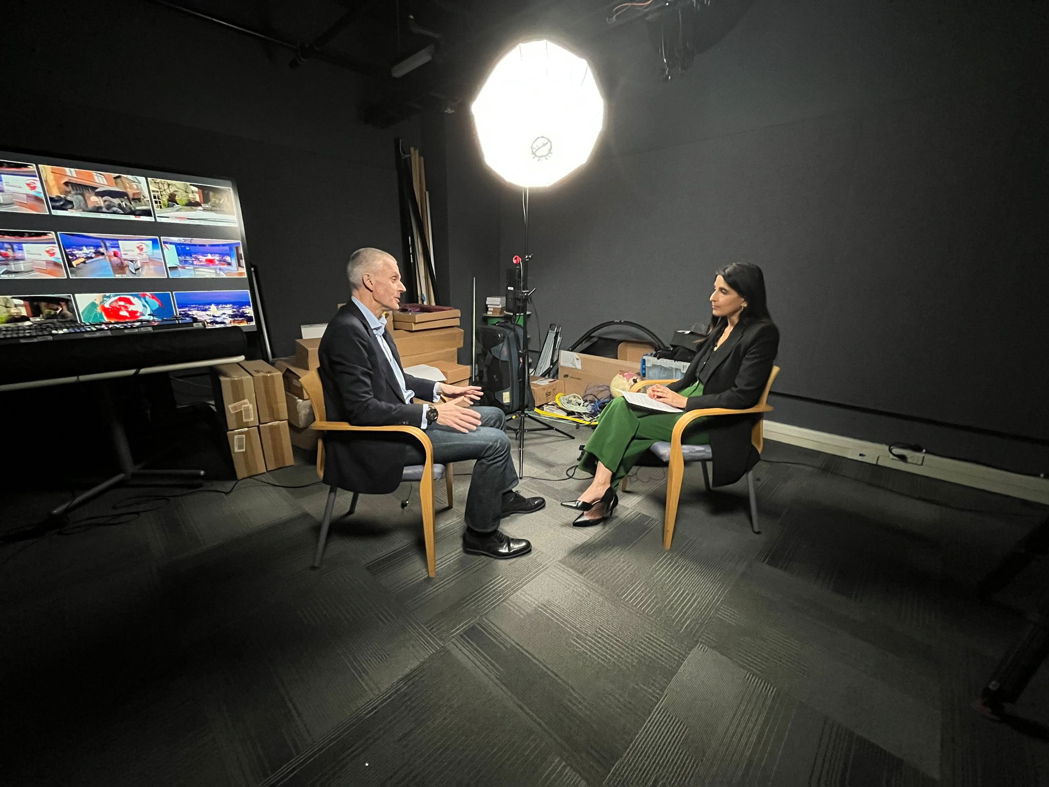 A man sits across from a woman with a light shining on them. 