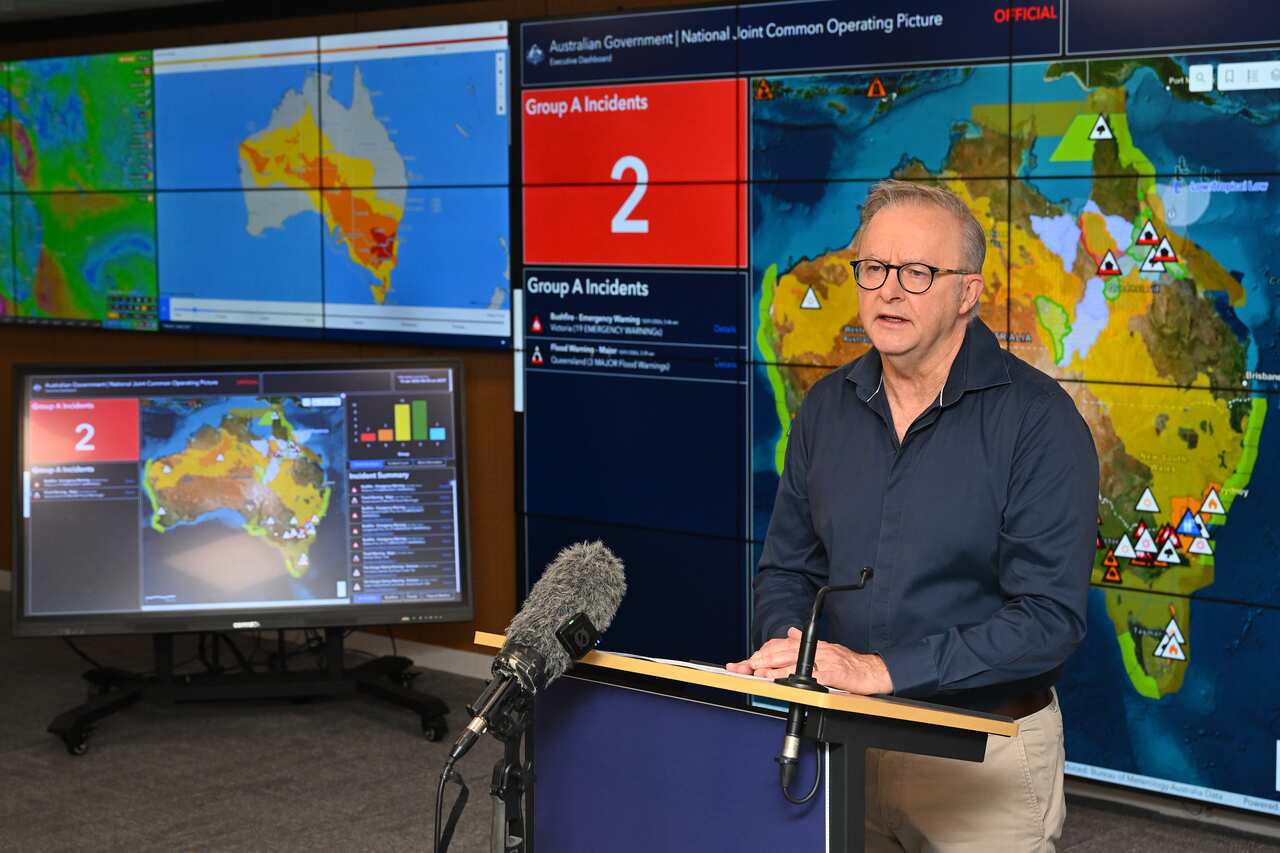 Anthony Albanese at a press conference in front of a weather map