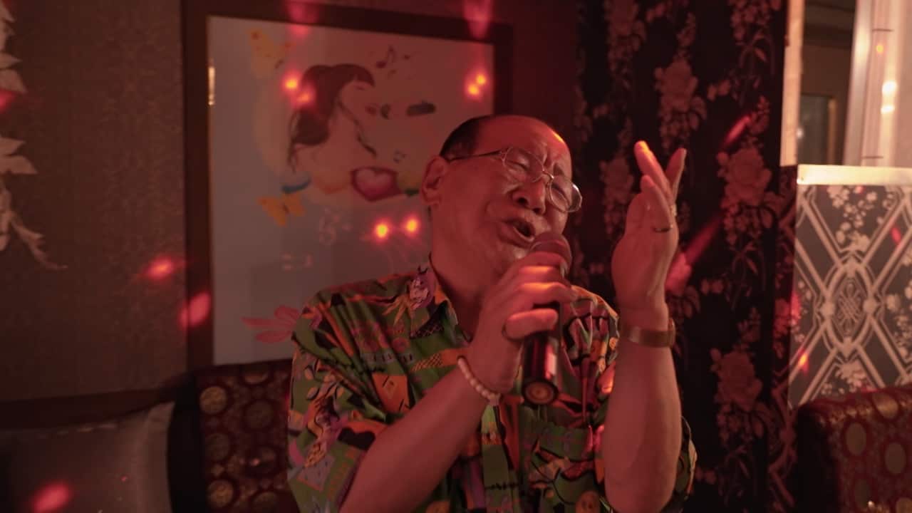 An older man singing.