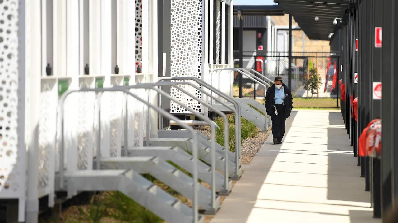 A person wearing a face mask employee walking along a path at the newly constructed Victorian quarantine accommodation hub in Mickleham, Melbourne.
