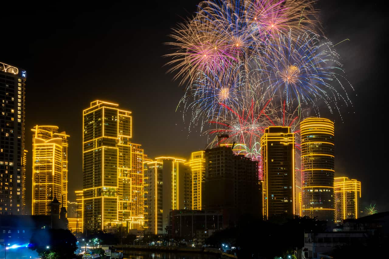 Fireworks over a city lit up with yellow lights