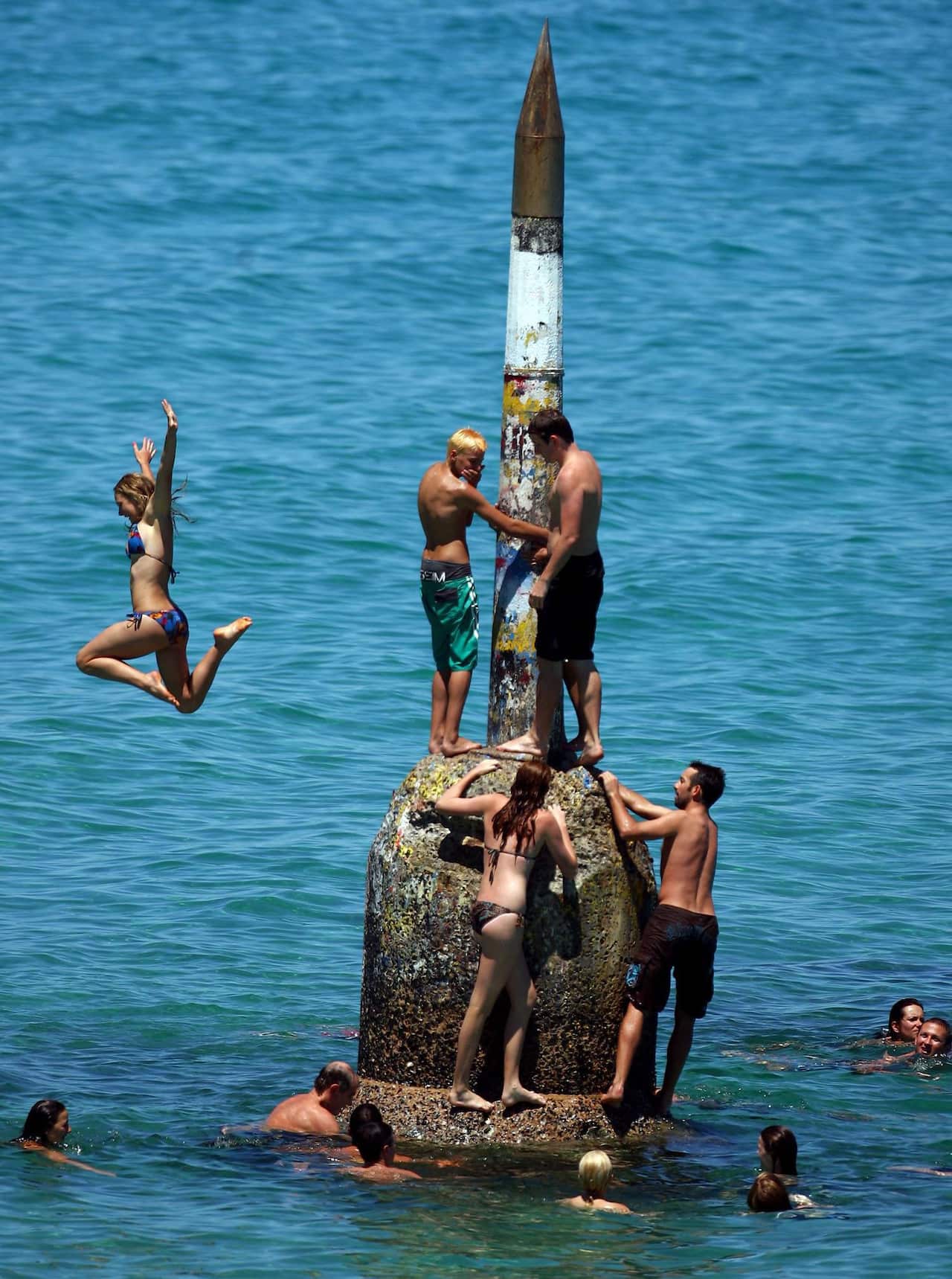 People stand on a structure floating in the ocean