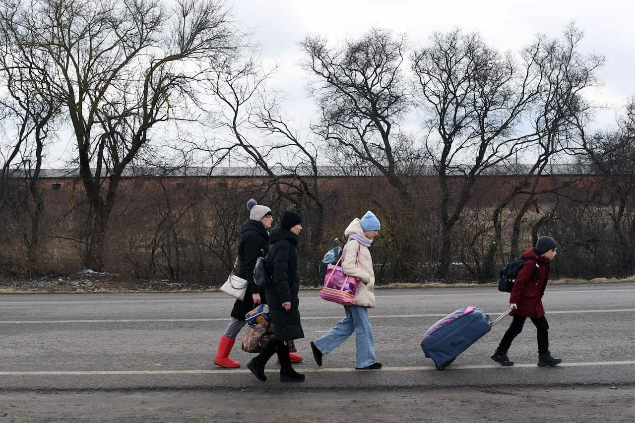 A Ukrainian family walks towards the Ukraine-Poland border as they flee the conflict in their country.