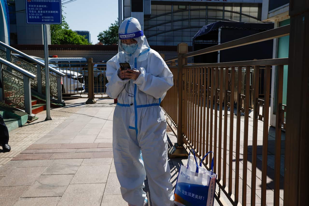 A traveller wears a protective suit at the Beijing Railway Station