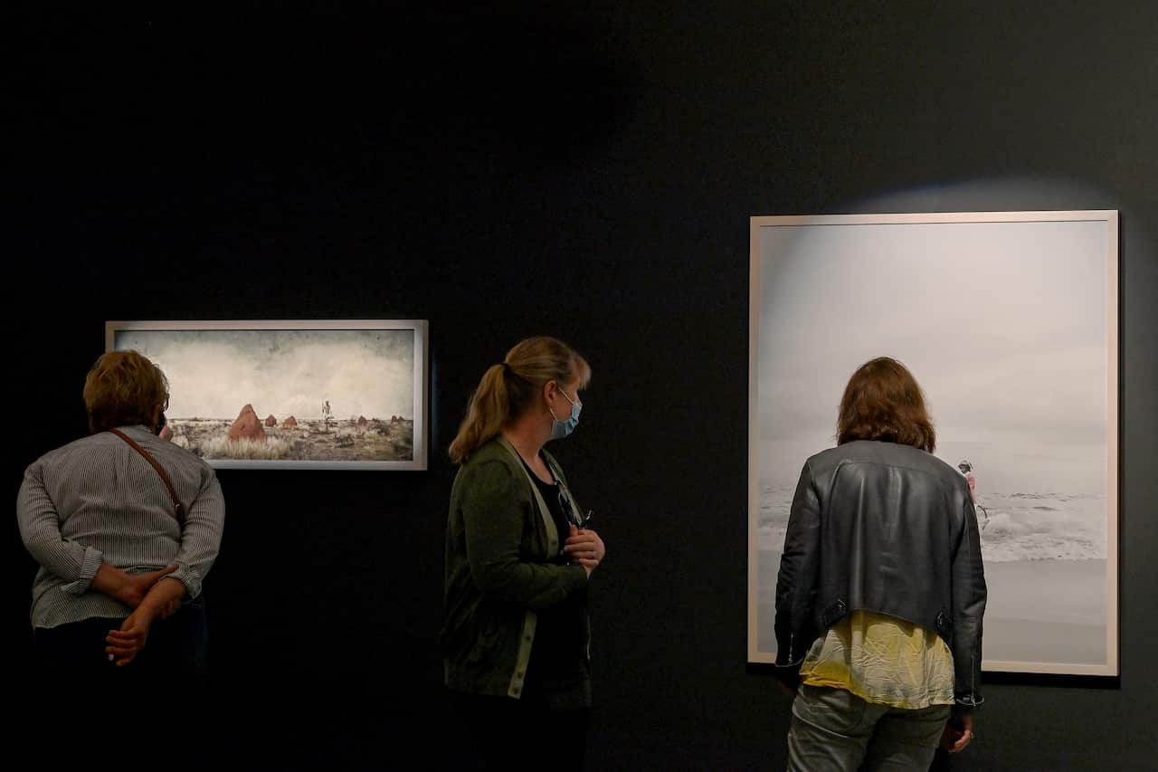 People looking at artworks in a gallery.