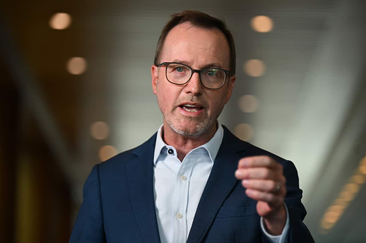 Australian Greens Senator David Shoebridge wearing a blue suit speaks while gesturing with his left hand.