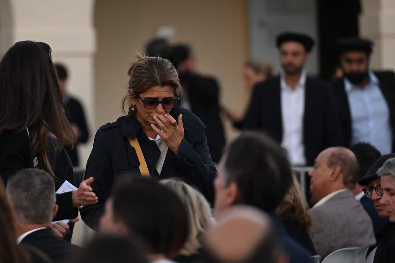 A woman gets emotional at a vigil.