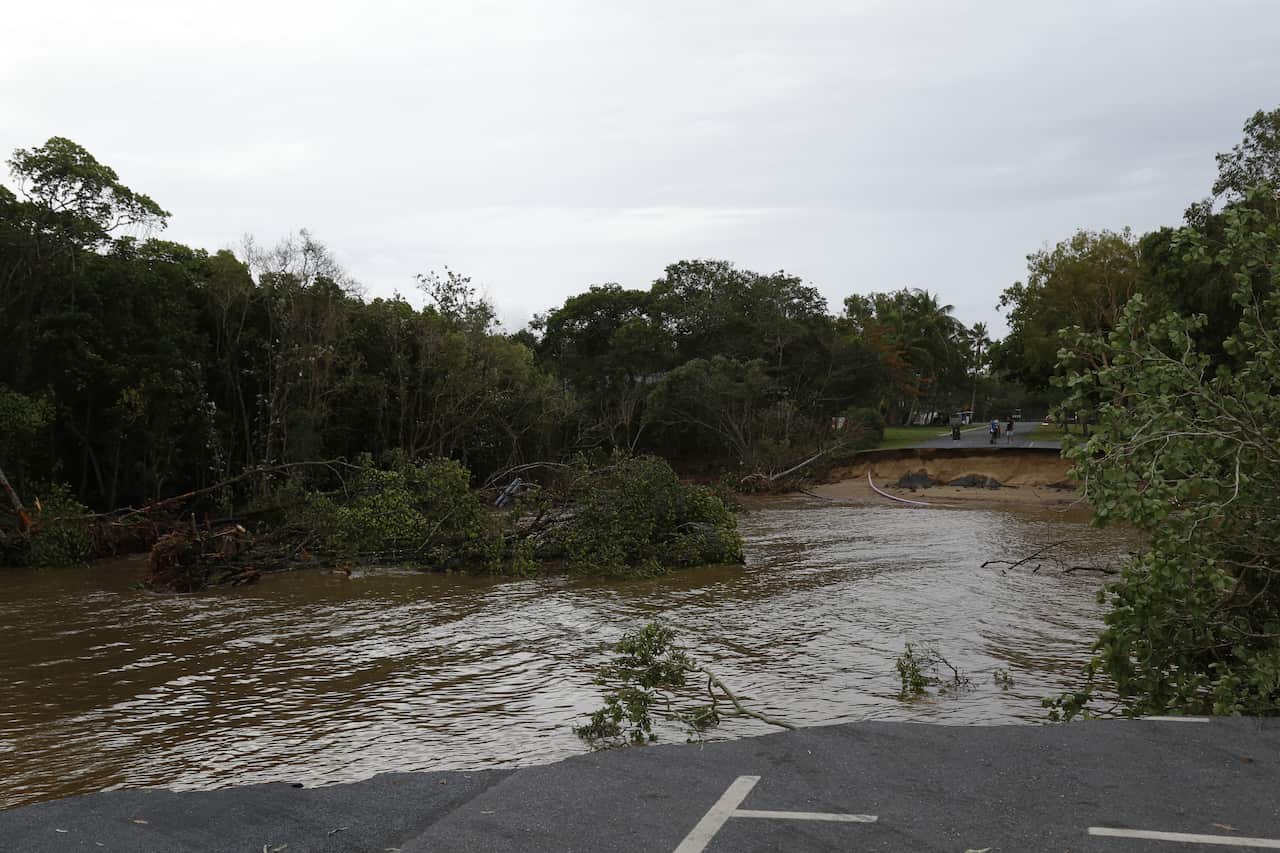 Flooding in Cairns, Australia -18 Dec 2023floodwaters destroyed a road surrounded by trees