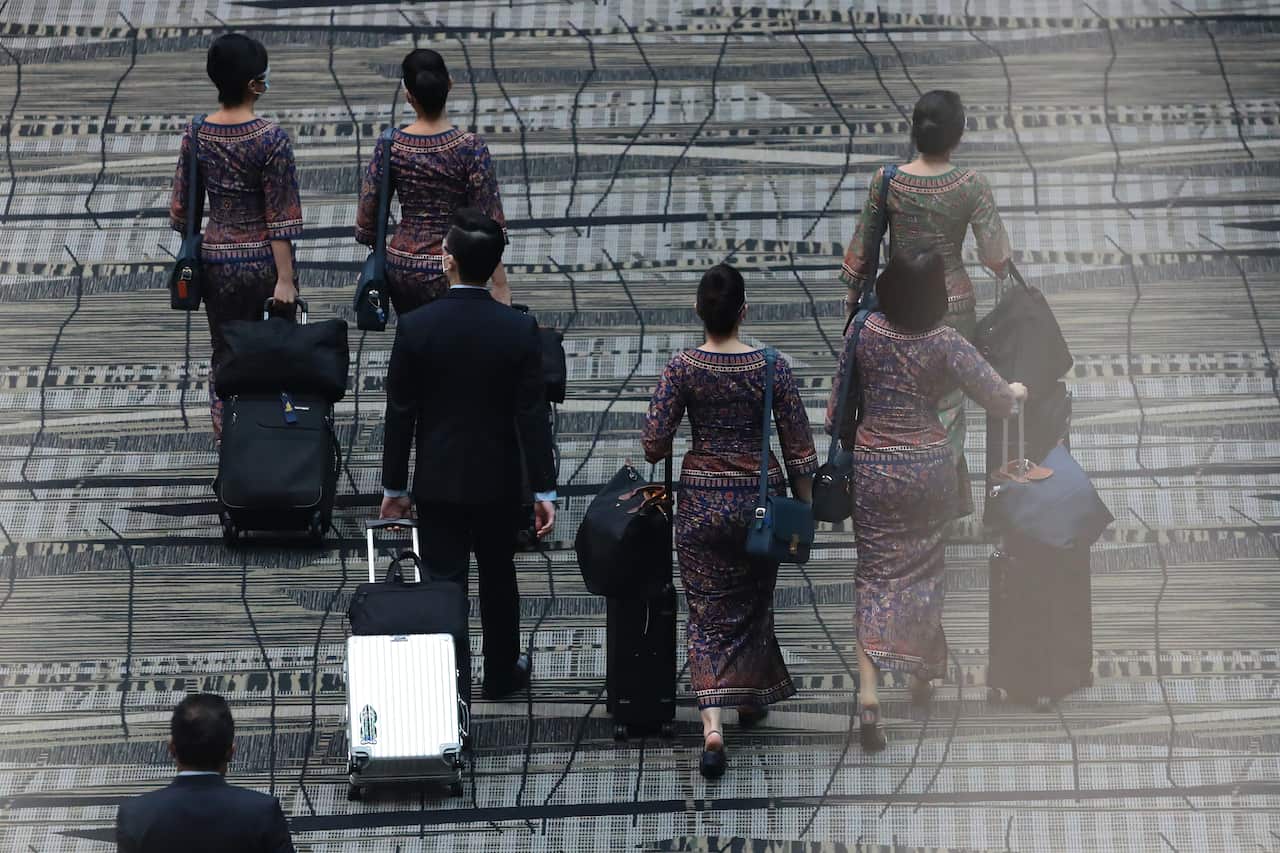 Flight crew walking with their luggage.