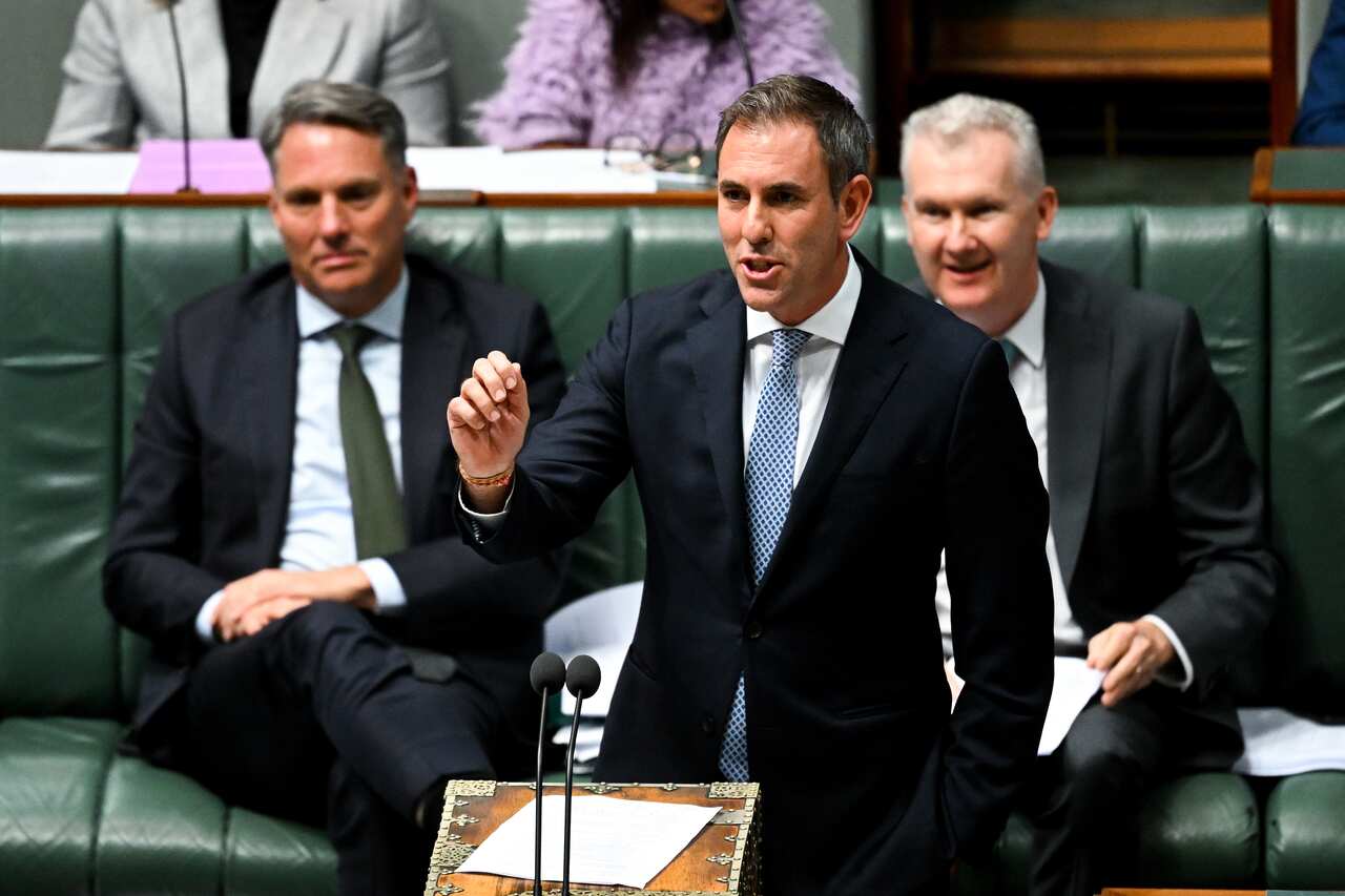 Man in a suit speaking at lectern.