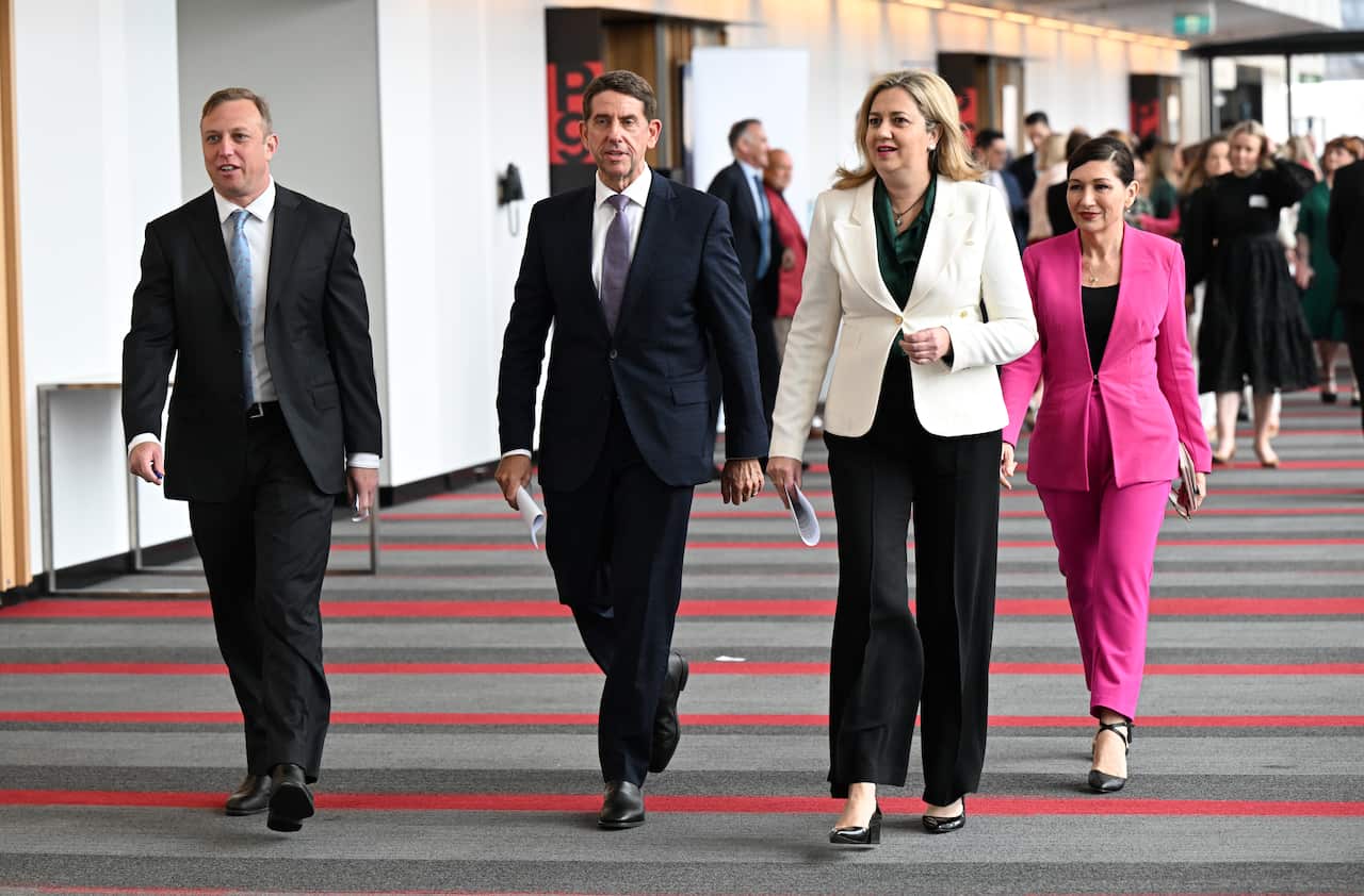 Four people walking in a line.