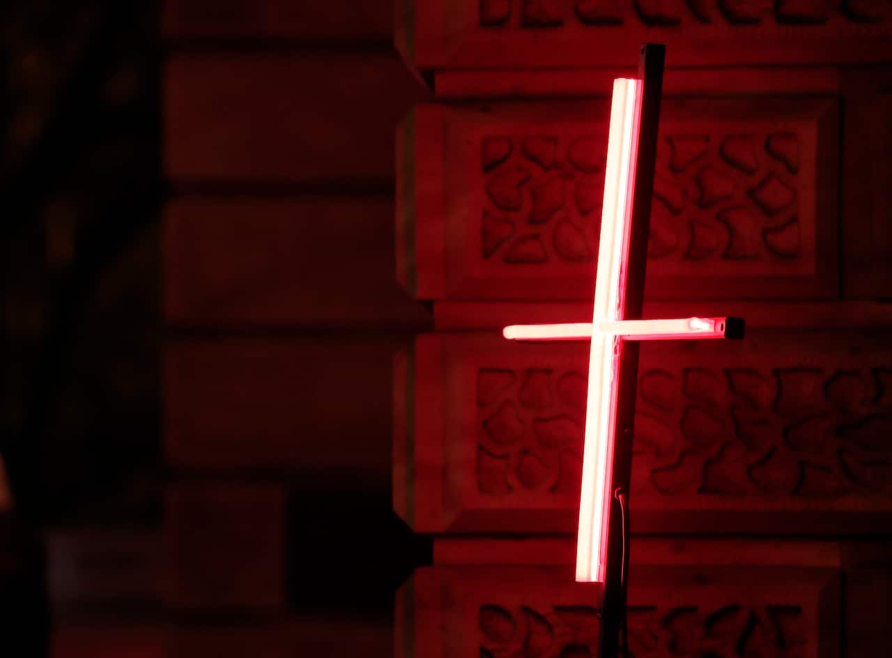 An illuminated red cross. 