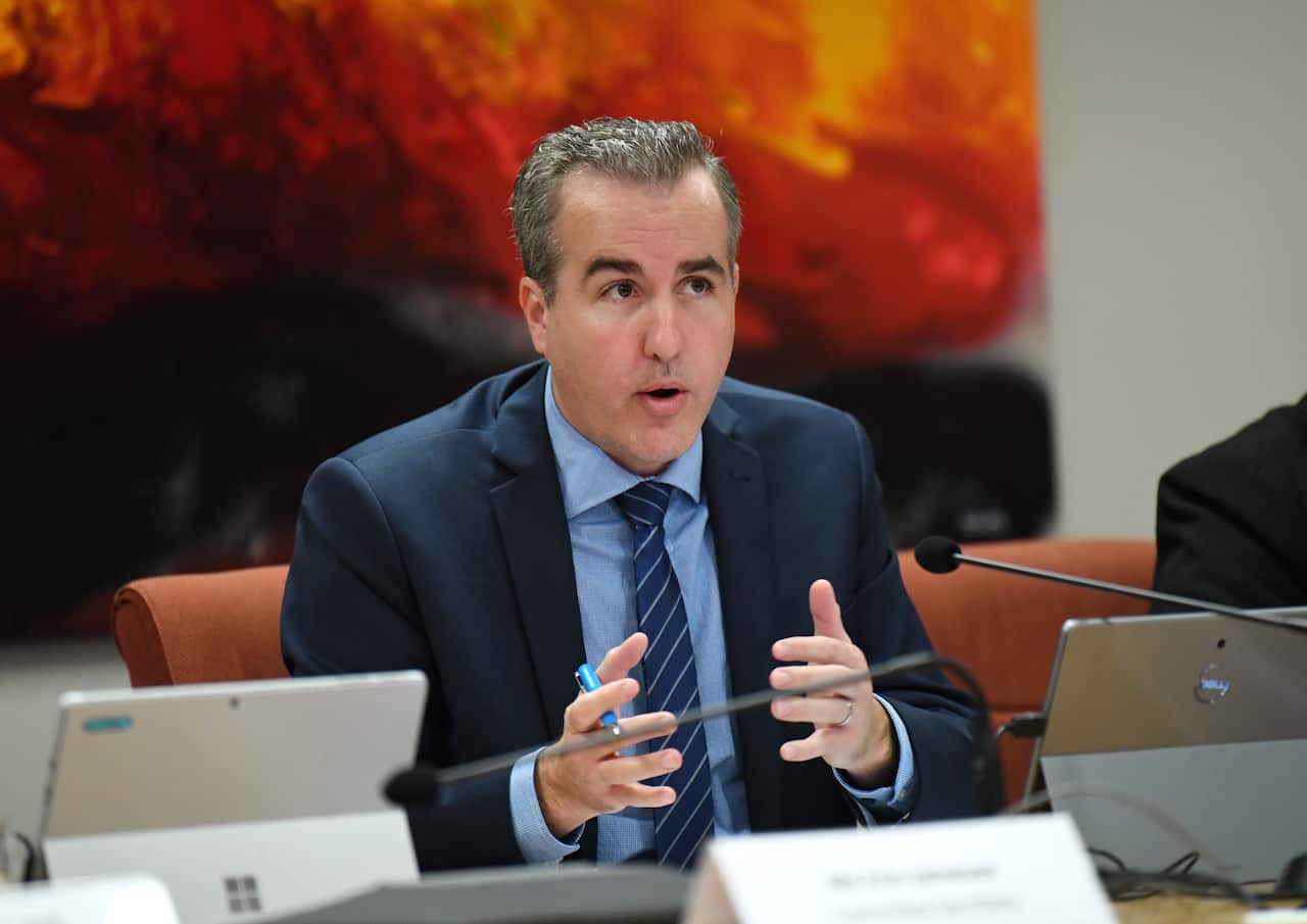 A man in a suit speaks at a conference
