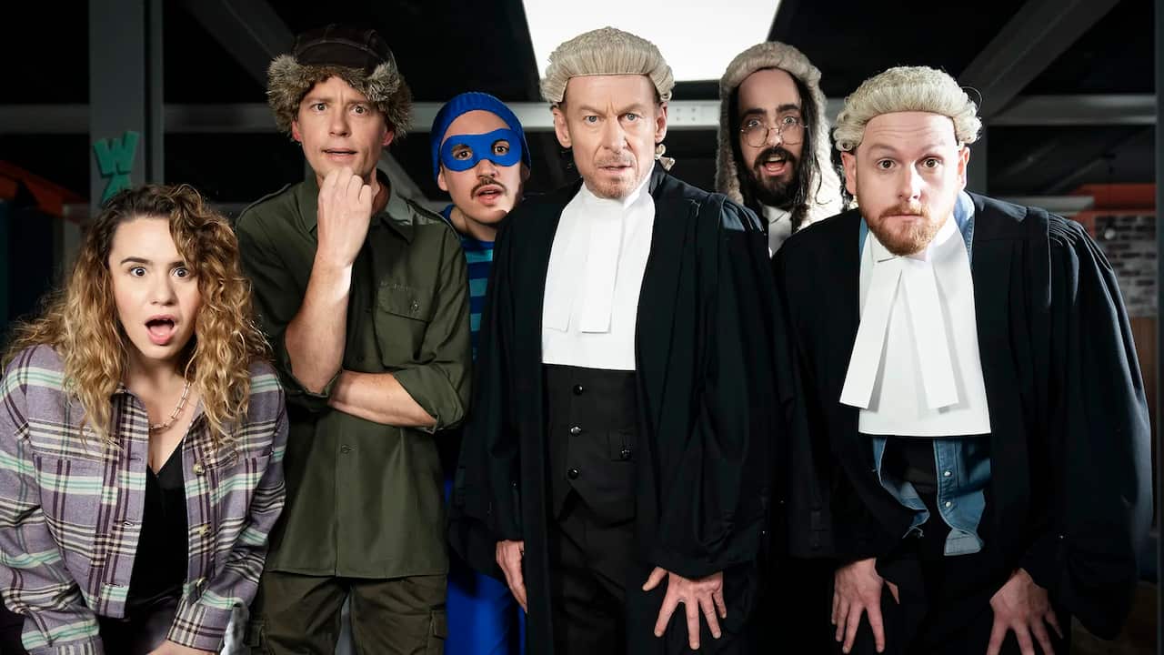 A woman and five men with expressions of shock and astonishment on their faces. Three of the men are dressed in court robes and wigs, while another is dressed in a blue burglar's outfit.