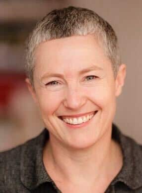 A woman with short, grey hair, smiling.