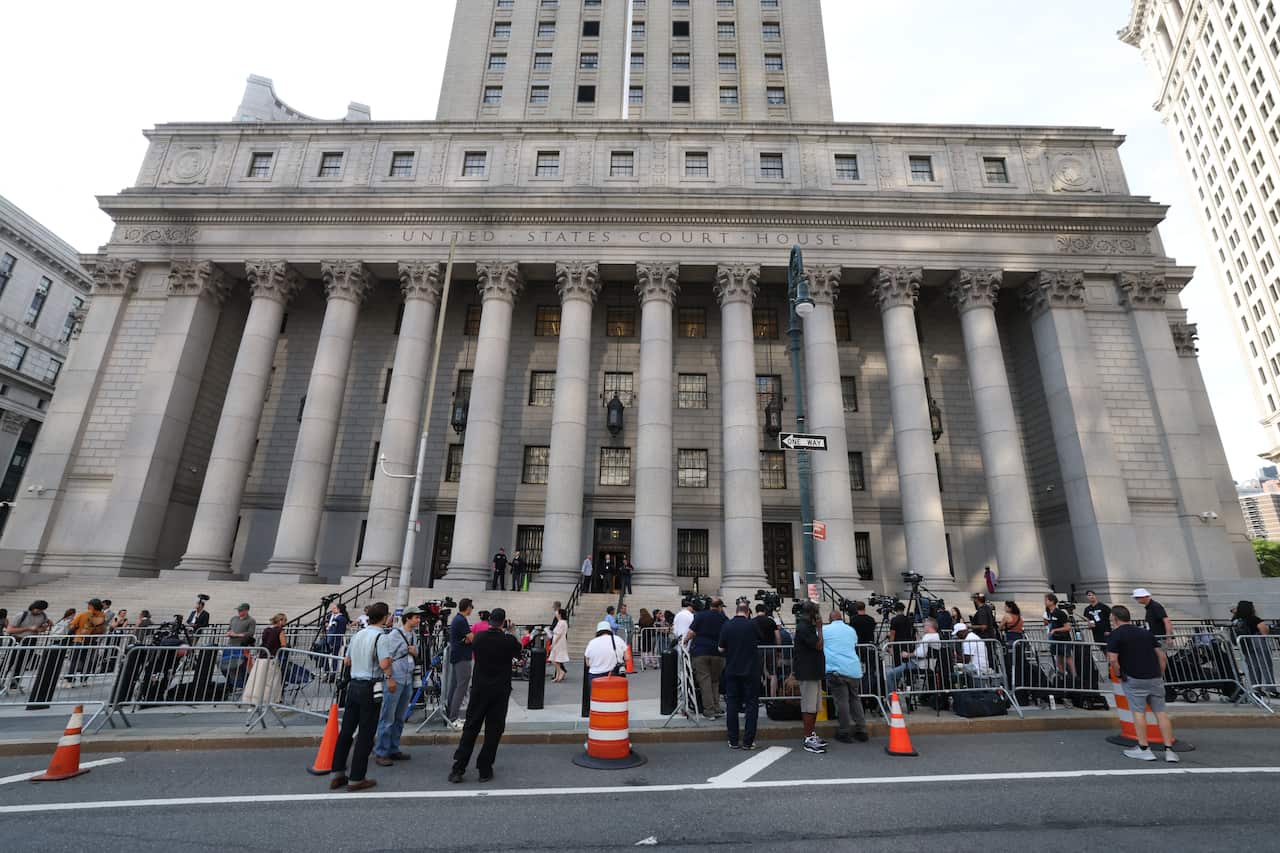 A neo-classical style court building in New York with people gathered outside.