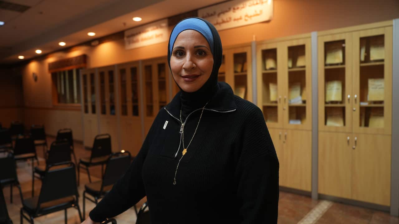 A woman in a black jacket and hijab