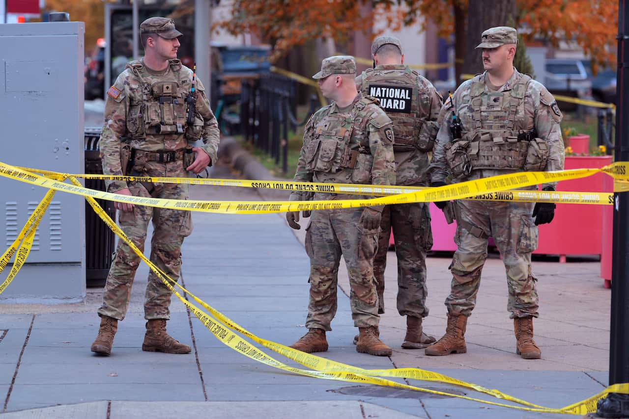 National Guard members standing behind yellow caution tape