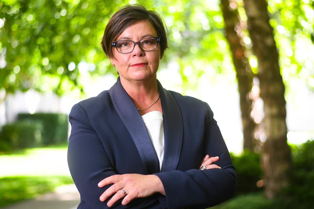 A woman standing with her arms folded.