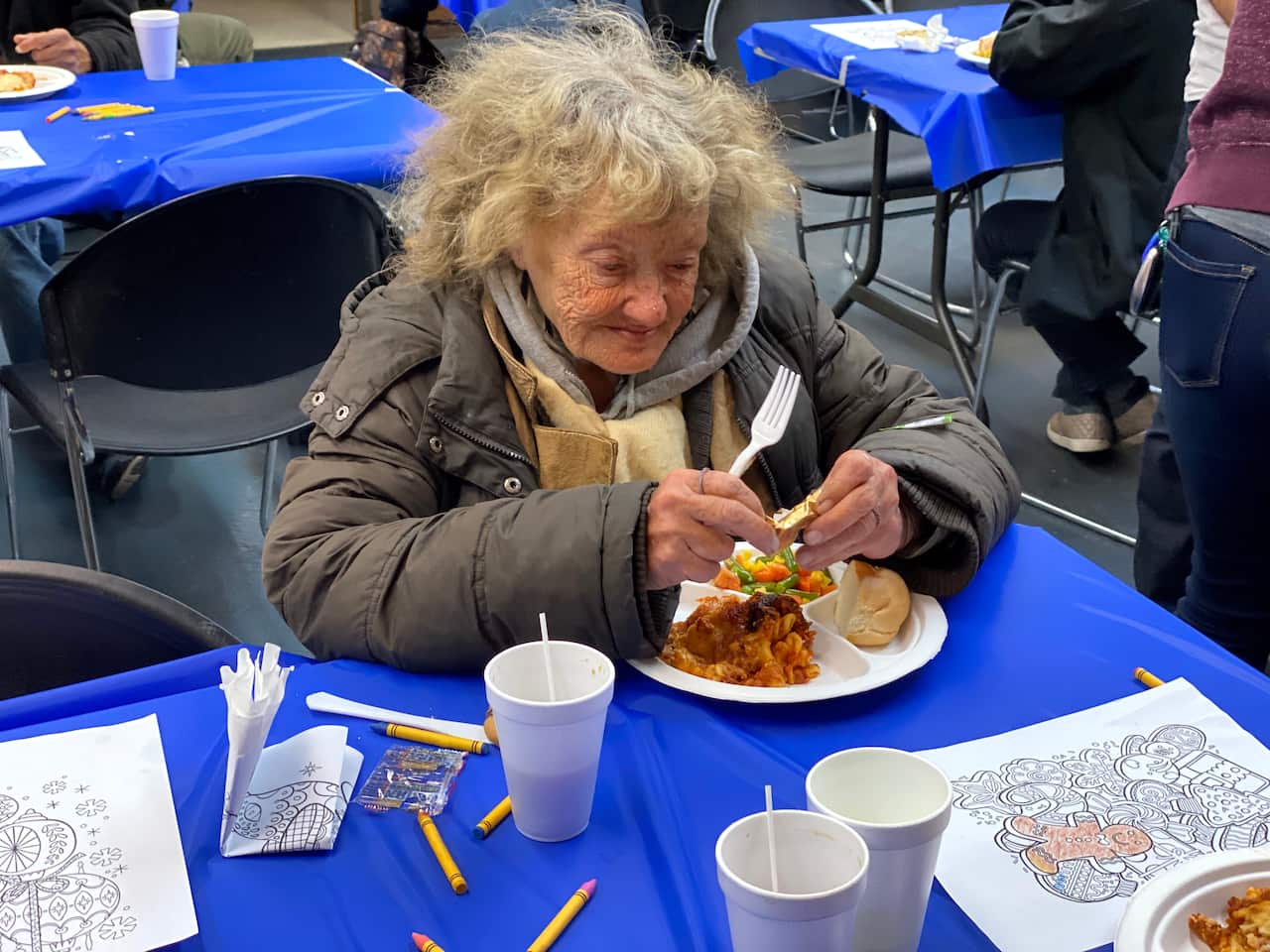 Homeless Senior Woman Eating a Meal in a Shelter