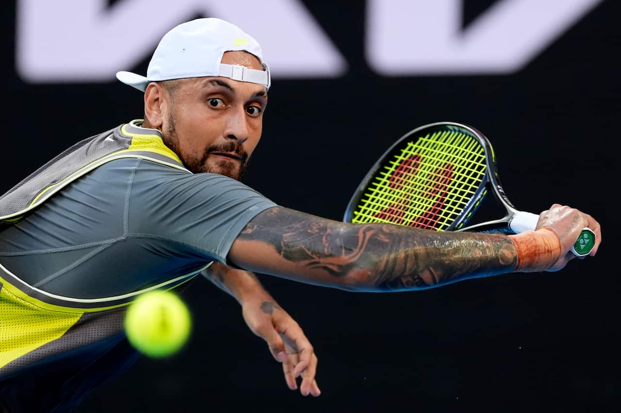 Nick Kyrgios swinging a tennis racket as a ball approaches.