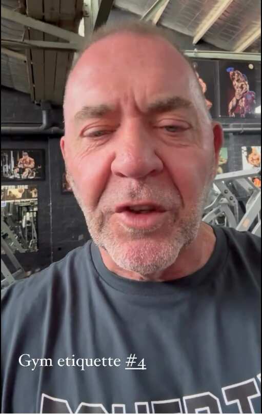 A man in a grey T-shirt speaking to the camera.