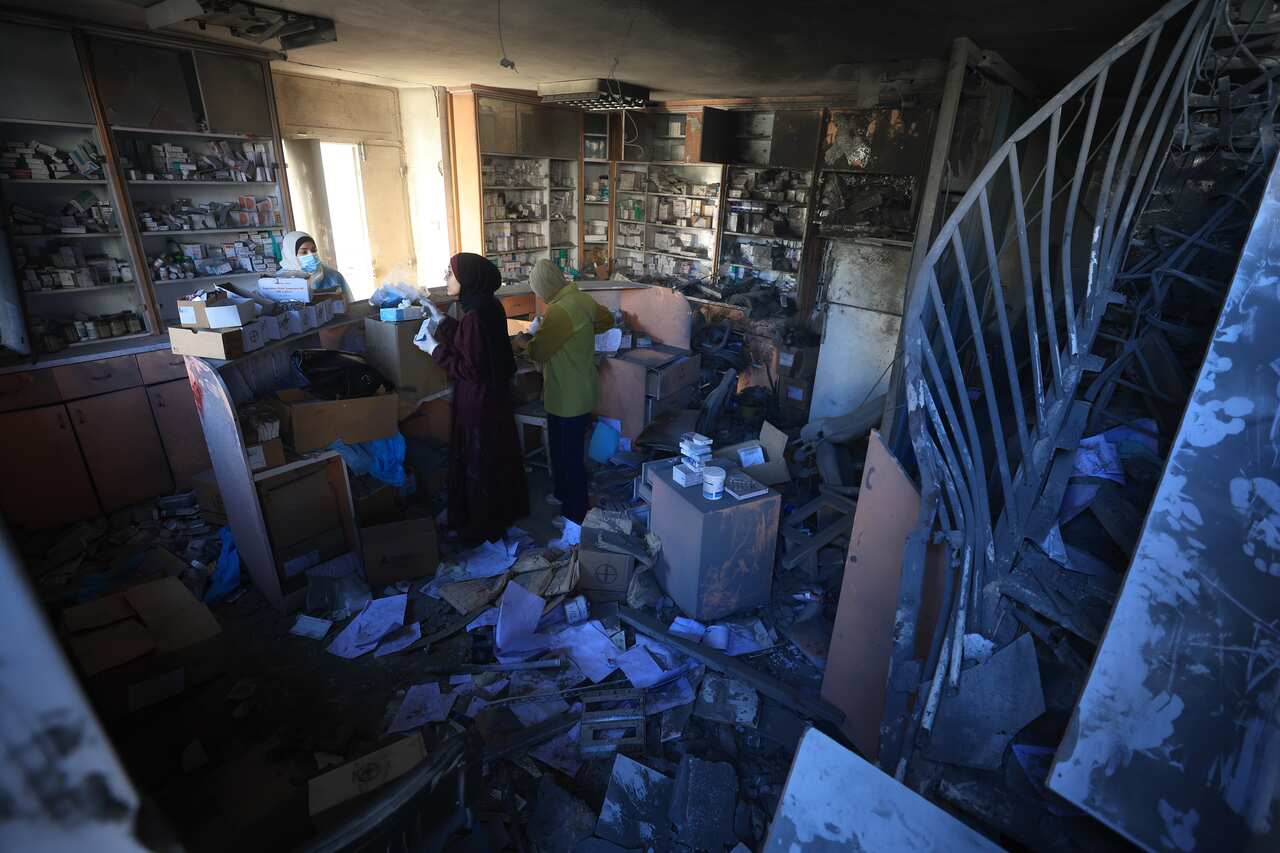 People inside a room that is strewn with debris.