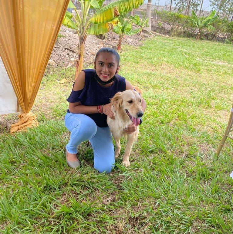 Nidhi Hirani posing next to a dog.  