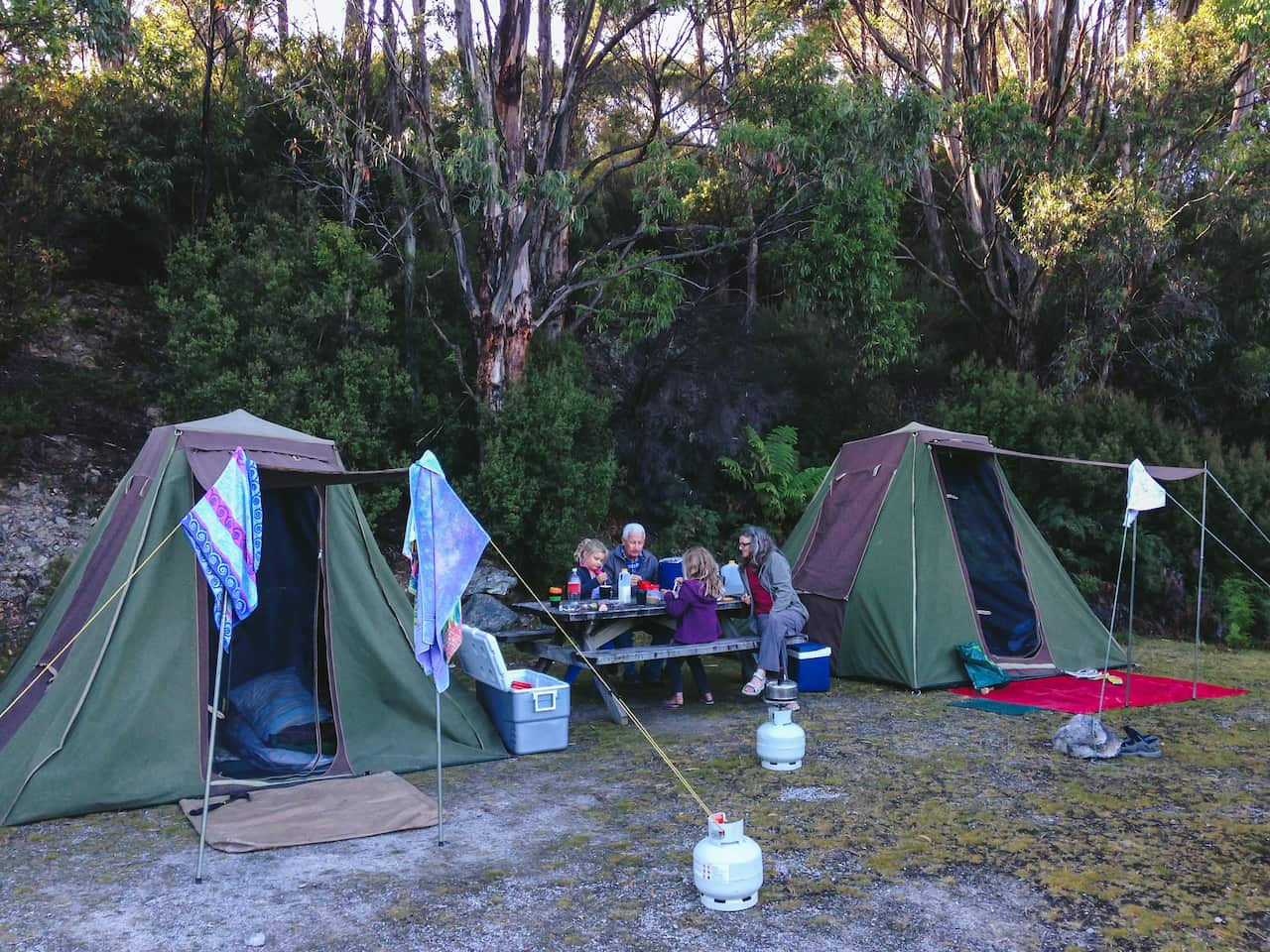 Children sitting with Grandparents at camp site