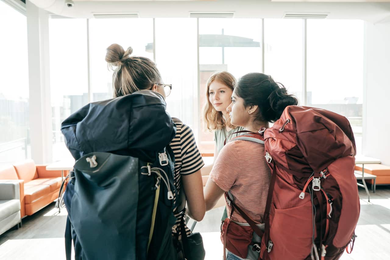 Three young women with large backpacks on their backs.