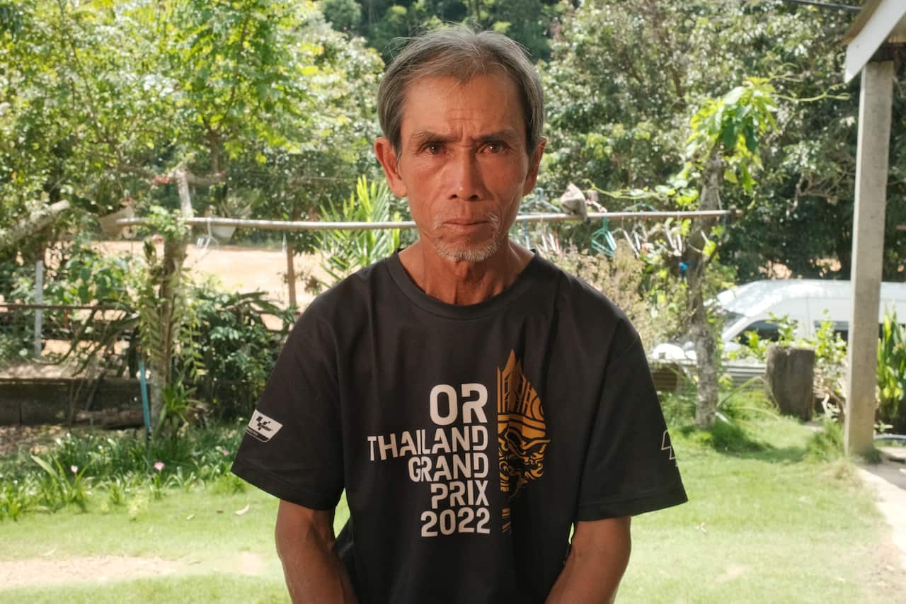 A man wearing a black t-shirt in a front yard