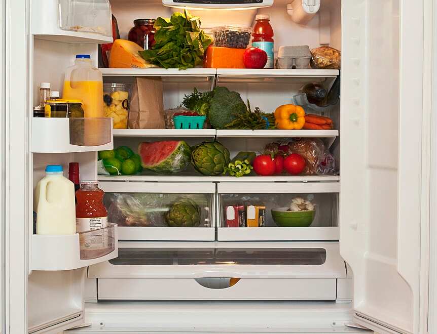 The inside of a refrigerator full of healthy food. There are lots of fruit and vegetables.